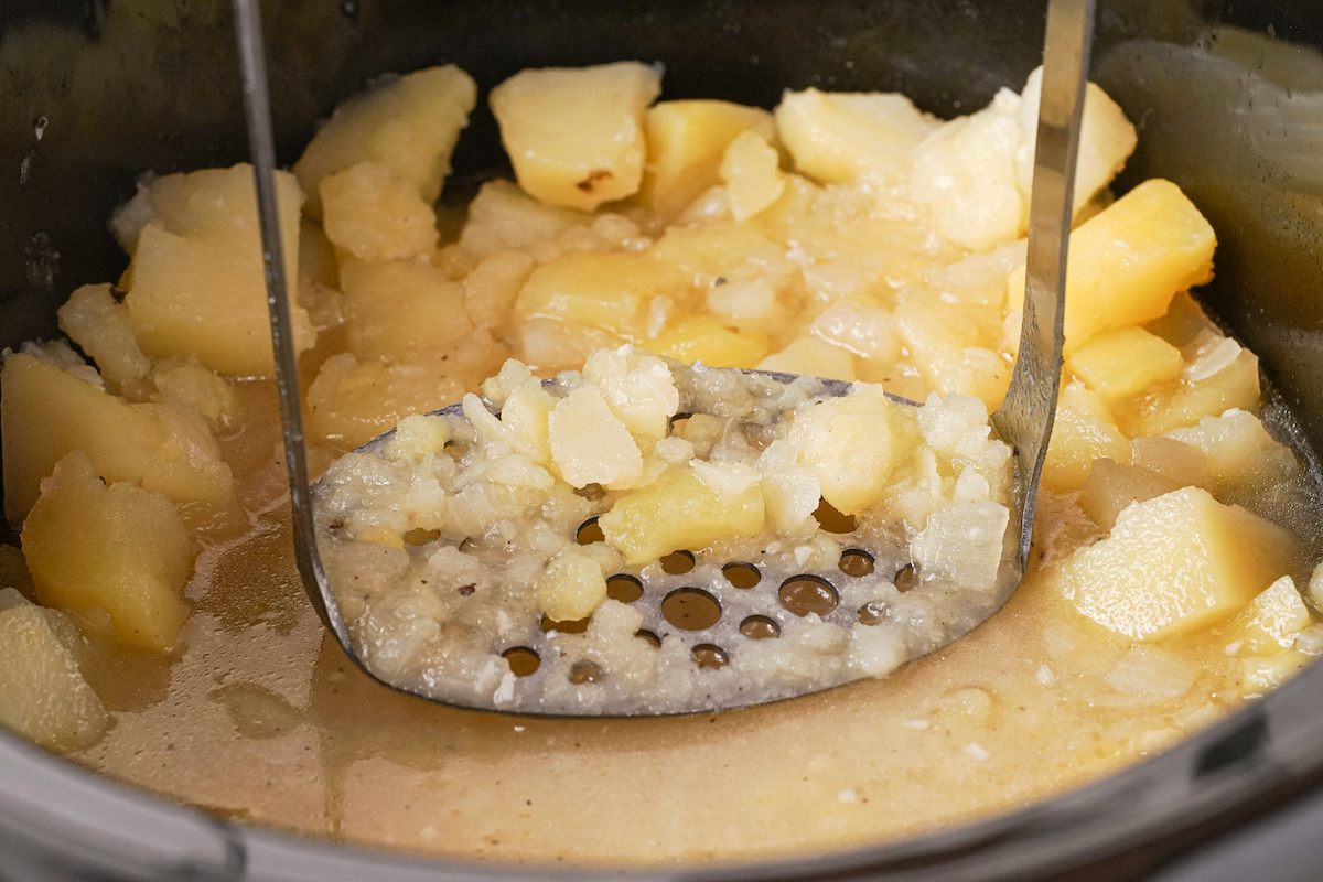 Partially mashing potatoes in a slow cooker.