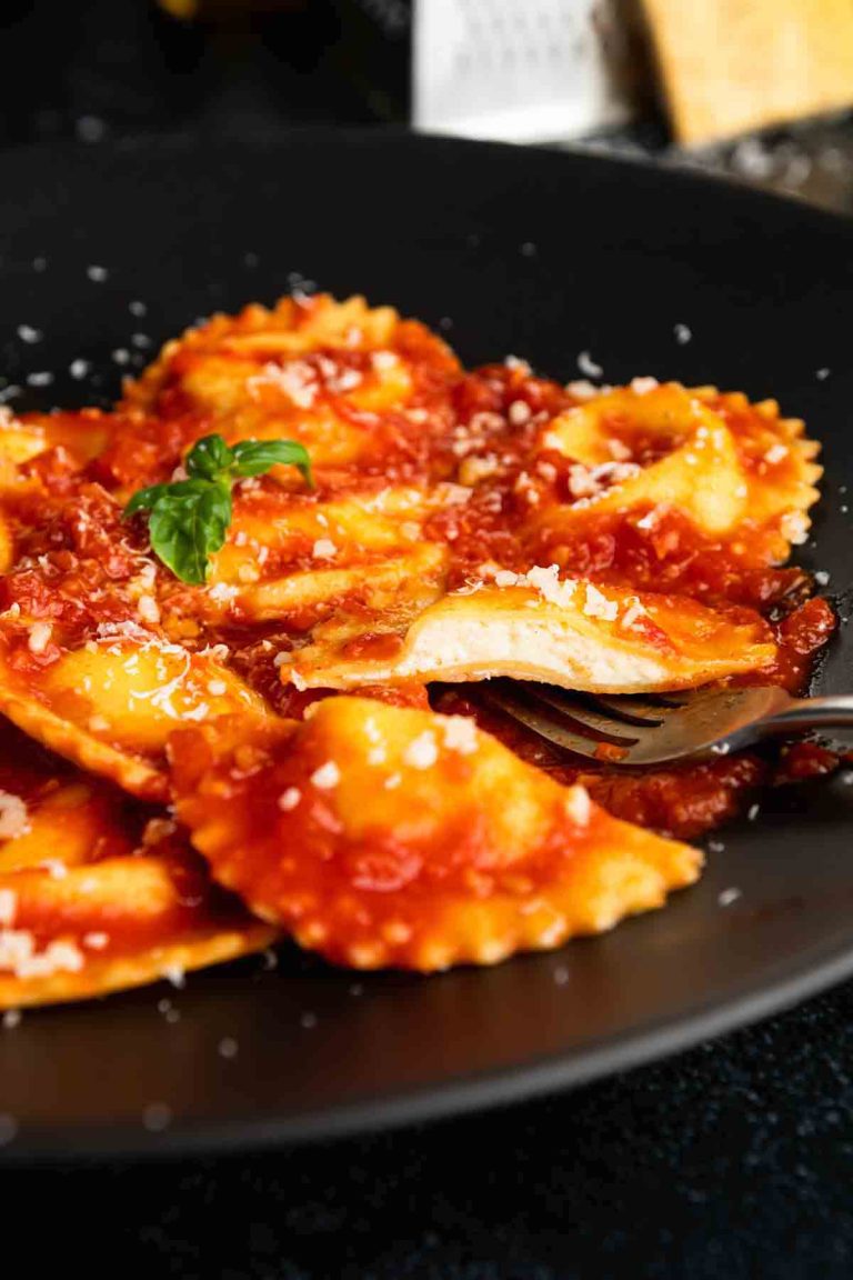 Photo of a black plate with homemade ravioli on it.