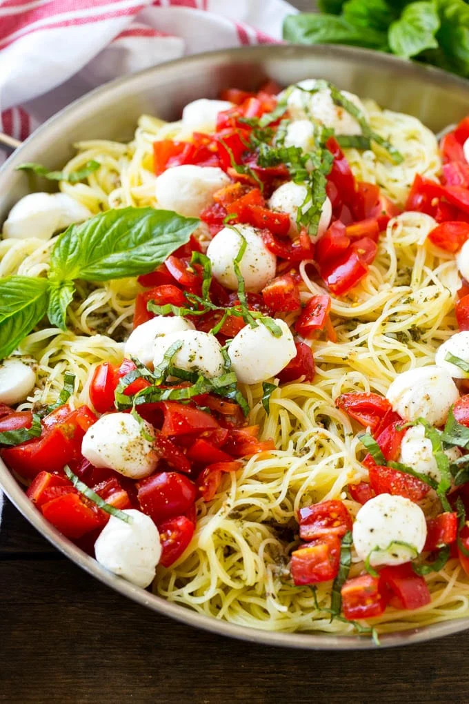 Photo of a skillet with Caprese Pasta with tomatoes.