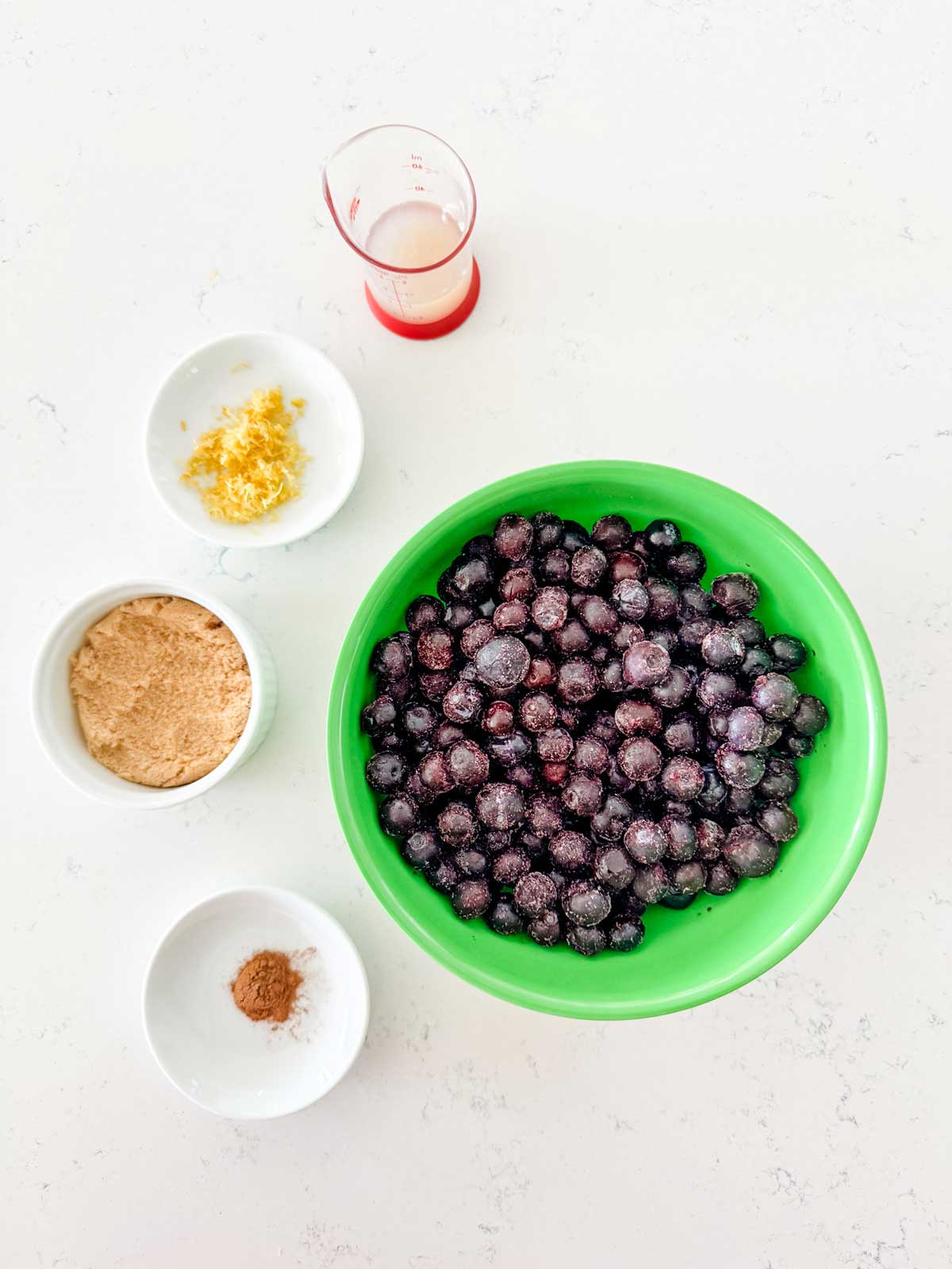 Overhead photo of blueberries, lemon juice, lemon zest, brown sugar, and cinnamon.