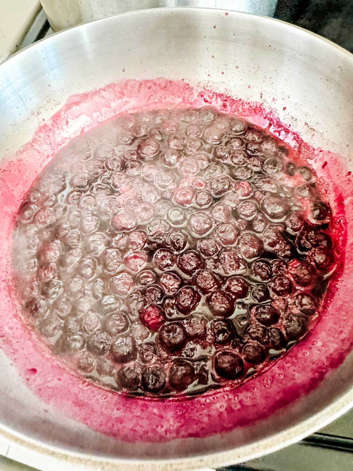 Blueberry compote cooking in a saucepan.