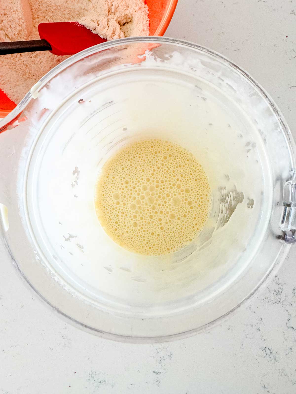 Melted butter, yogurt, eggs, honey, and vanilla that have been blended in a blender.