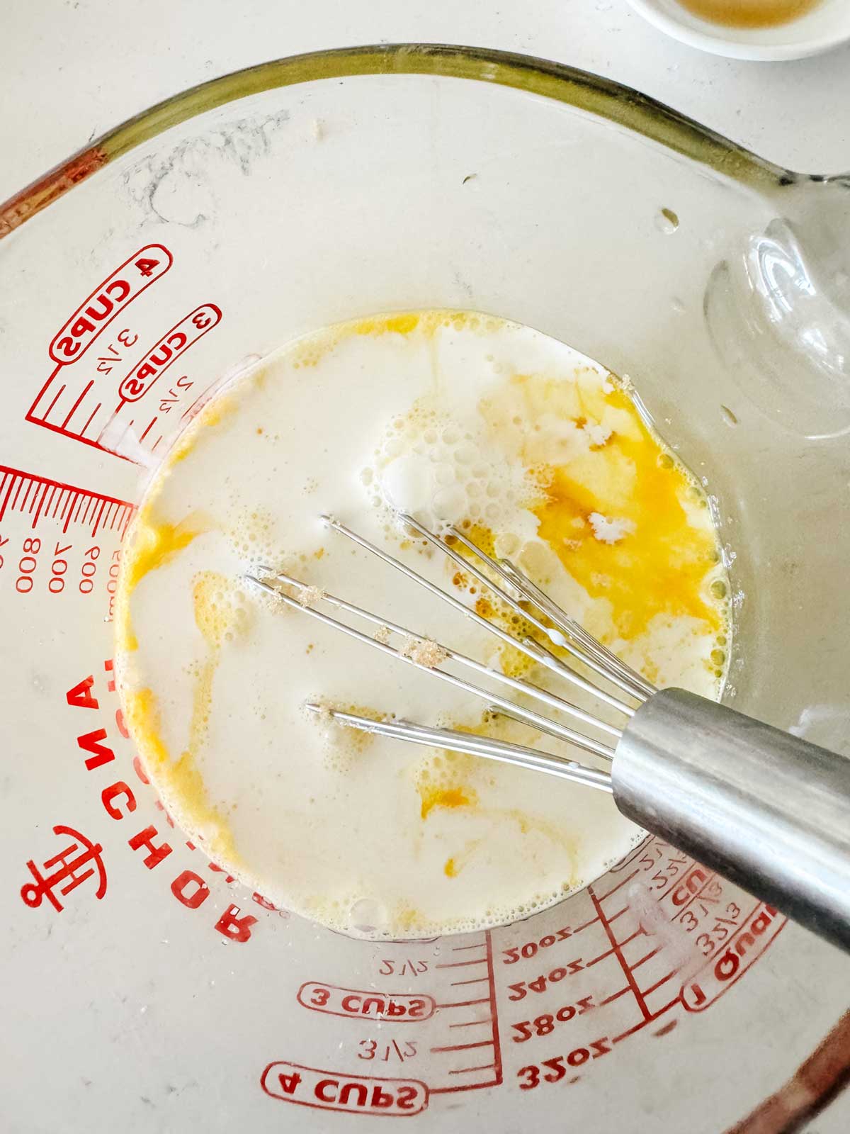 Eggs and cream mixed together in a large measuring cup.