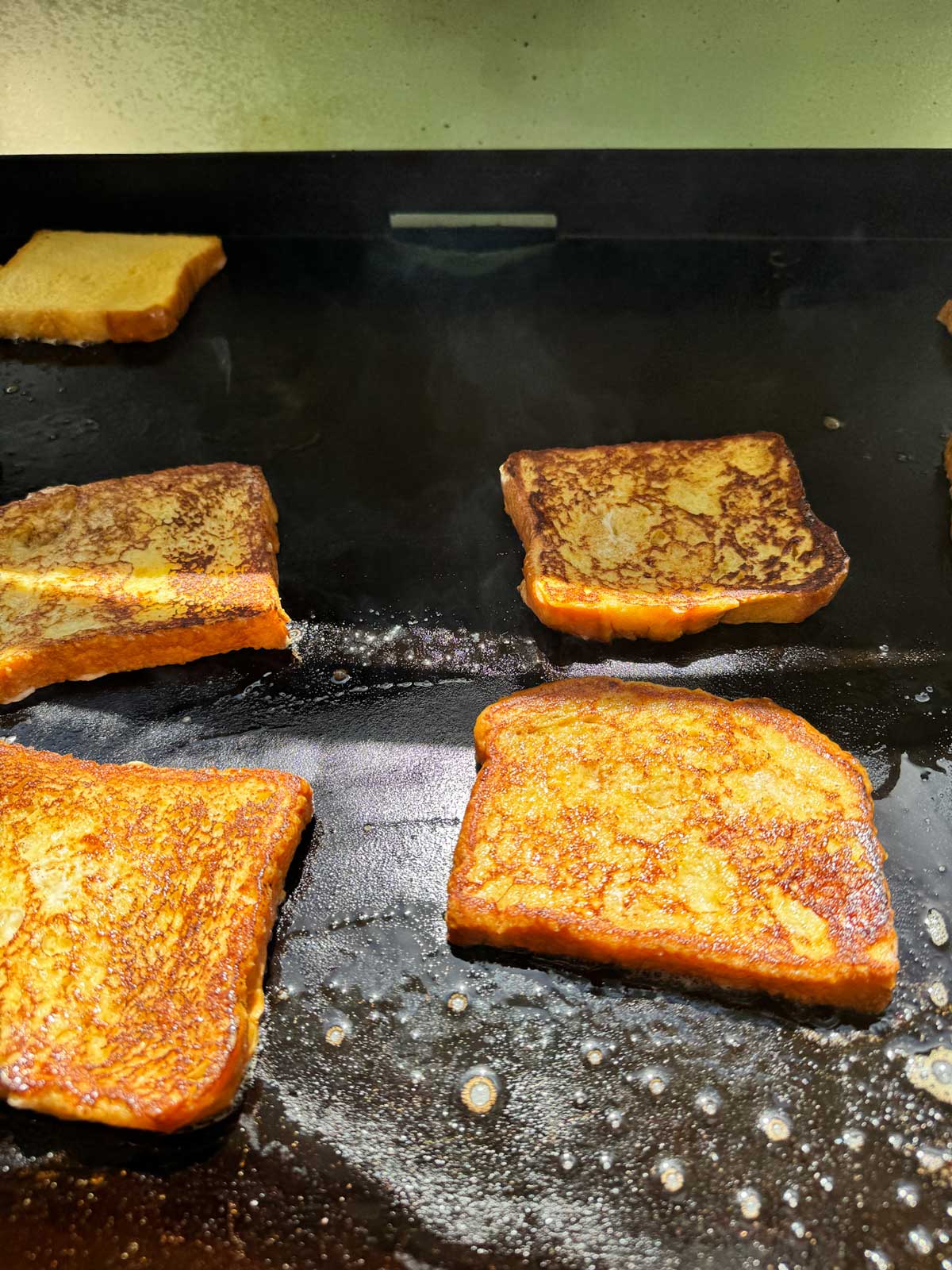 French toast cooking on a Blackstone griddle.