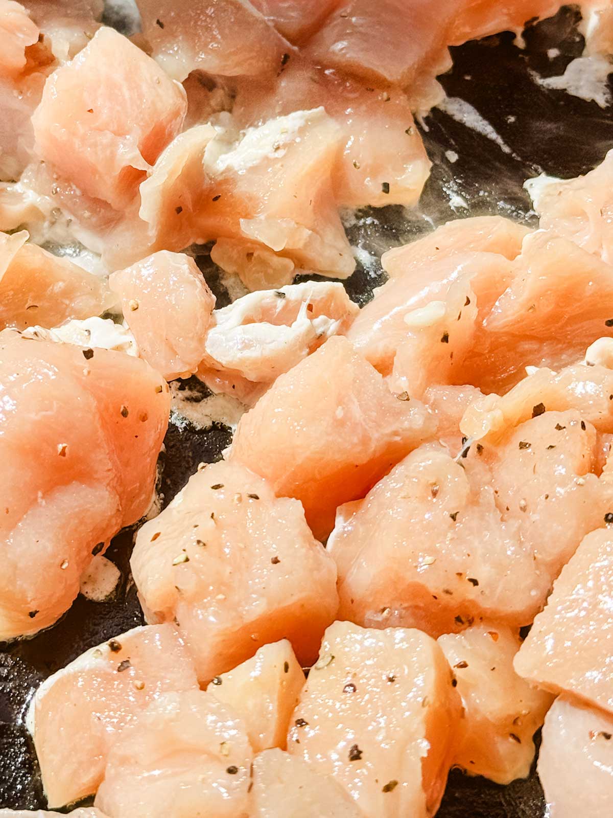 Diced chicken on a flat top griddle.