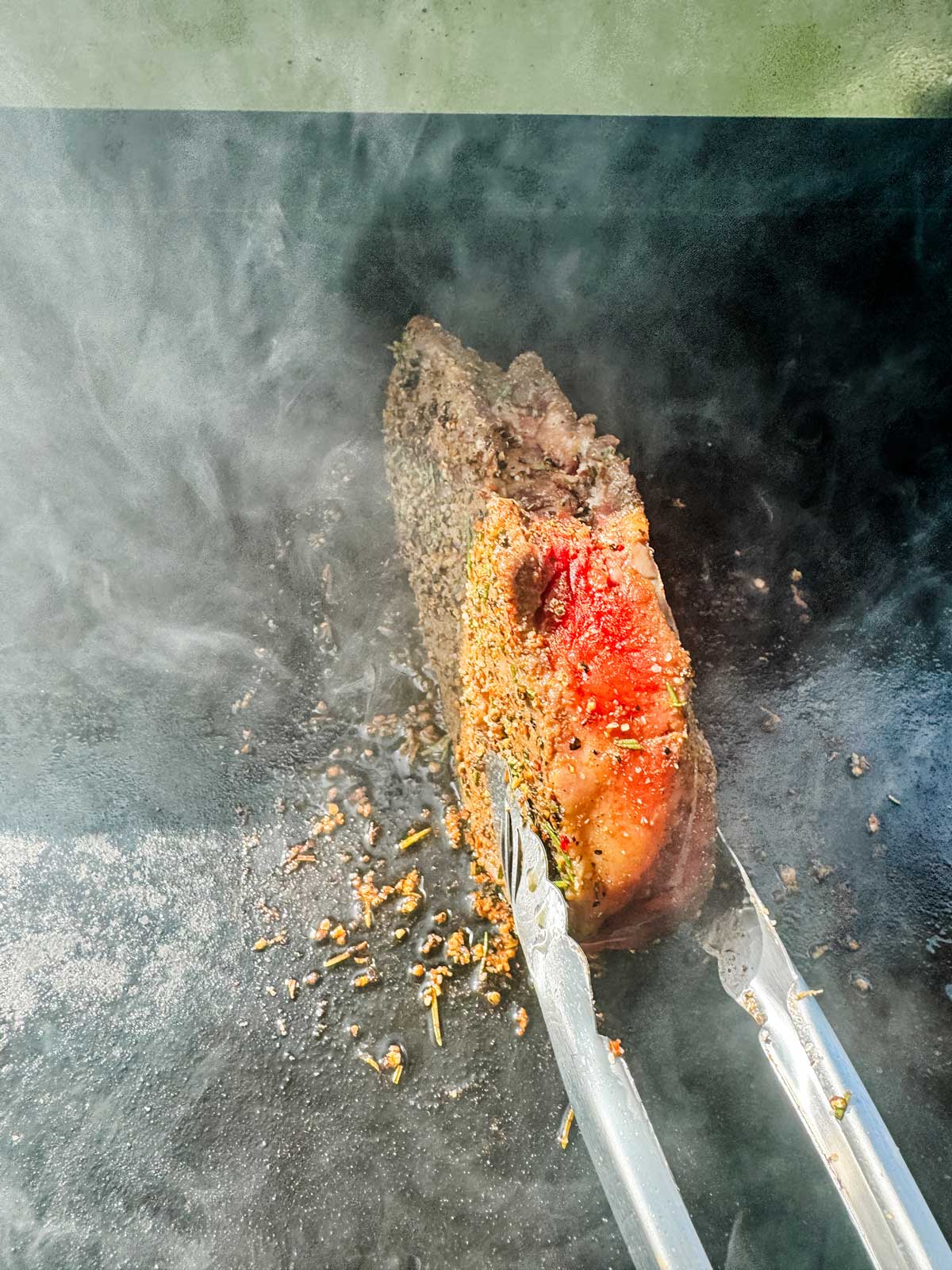 Cooking the sides of a steak on a Blackstone griddle.