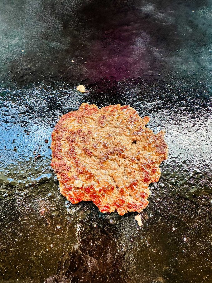 Photo of a smash burger cooking on a Blackstone Griddle.