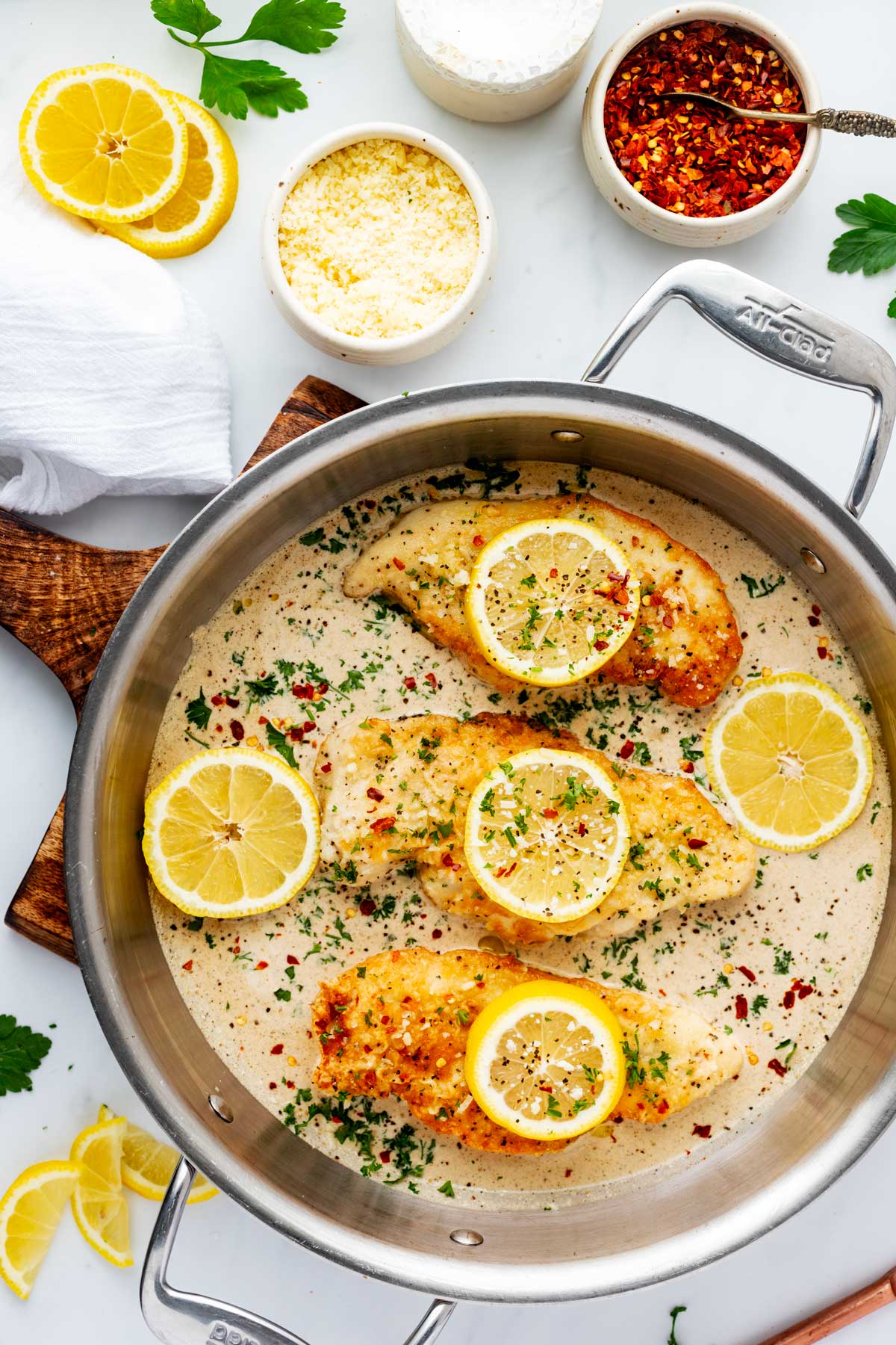 Overhead photo of lemon pepper chicken with cream sauce in a large skillet.