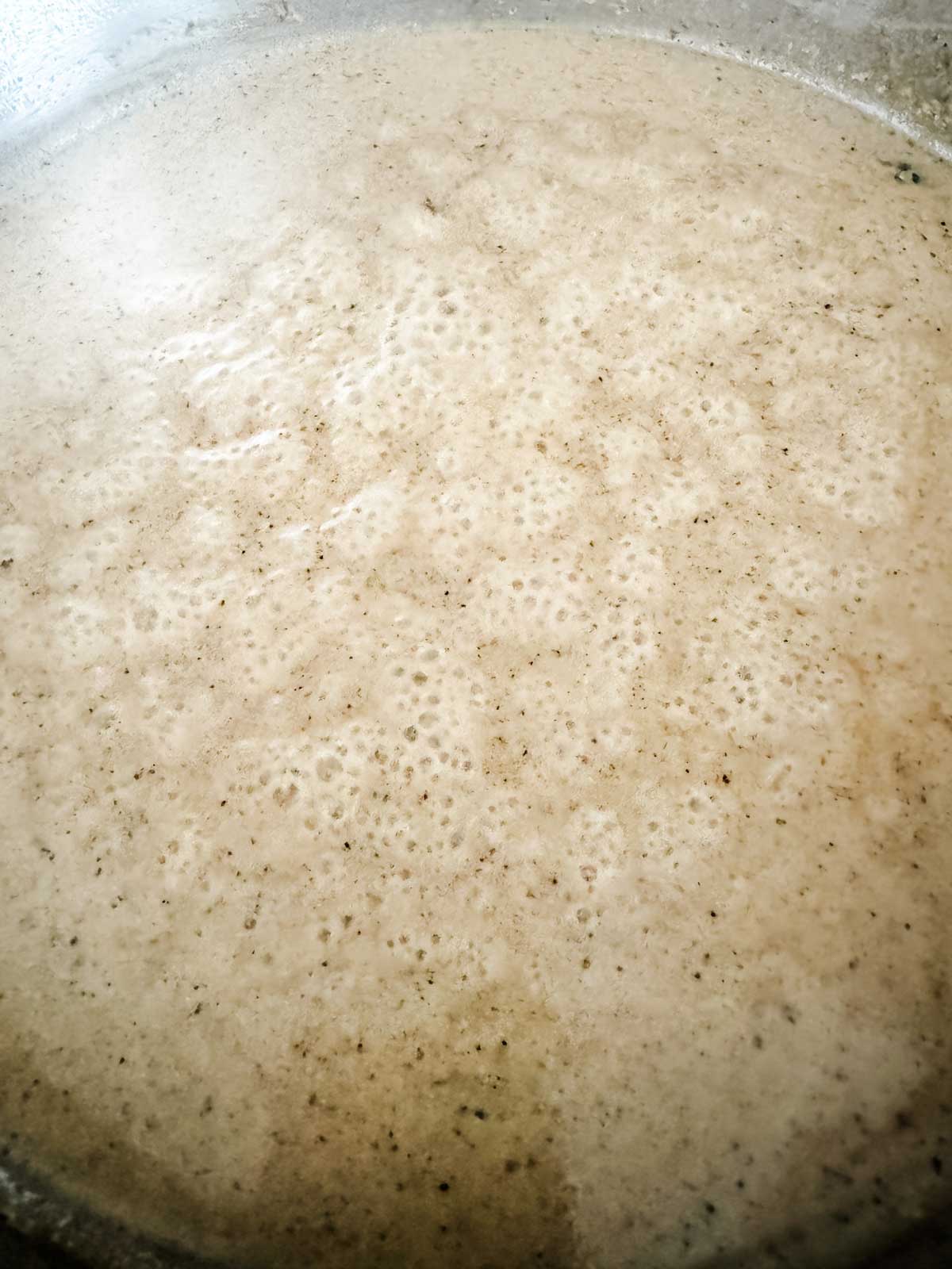 A peppery cream sauce being made in a large skillet.