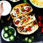 Overhead square photo of three tacos on a taco rack.