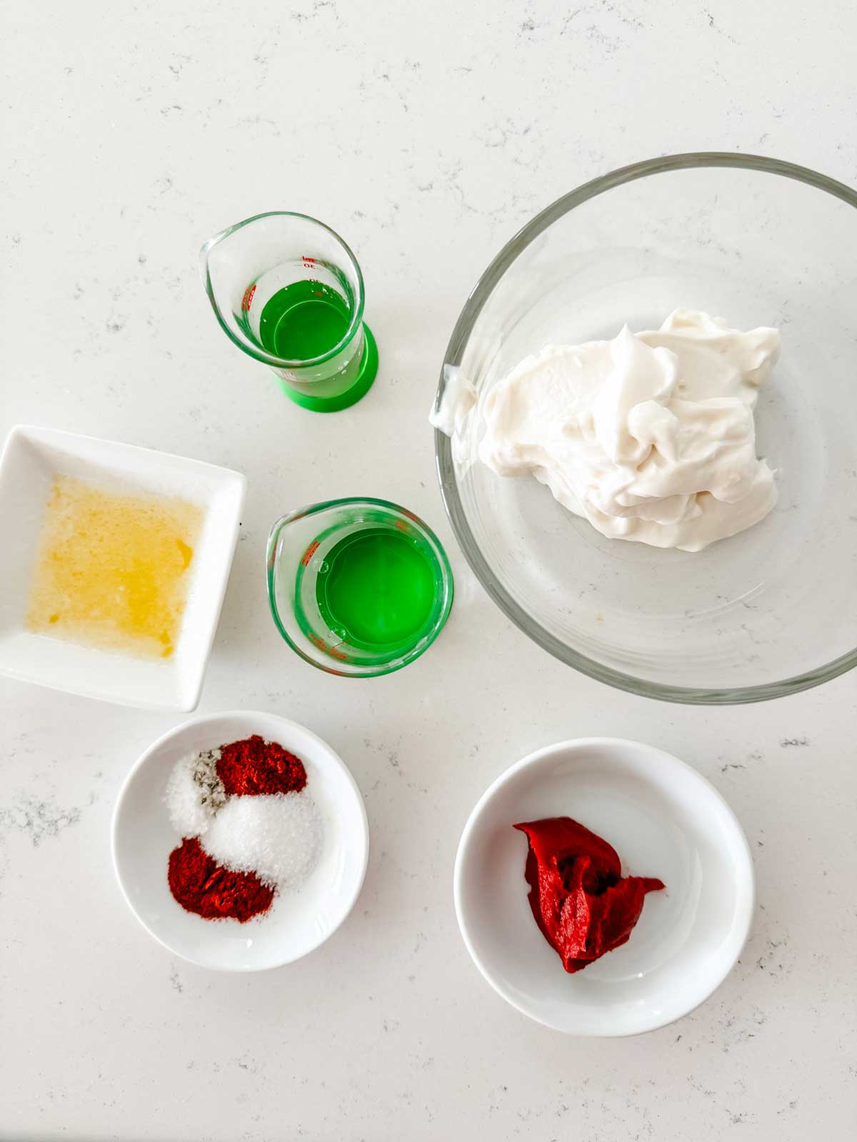 Overhead photo of mayo, tomato paste, seasonings, sugar, rice vinegar, butter, and water.