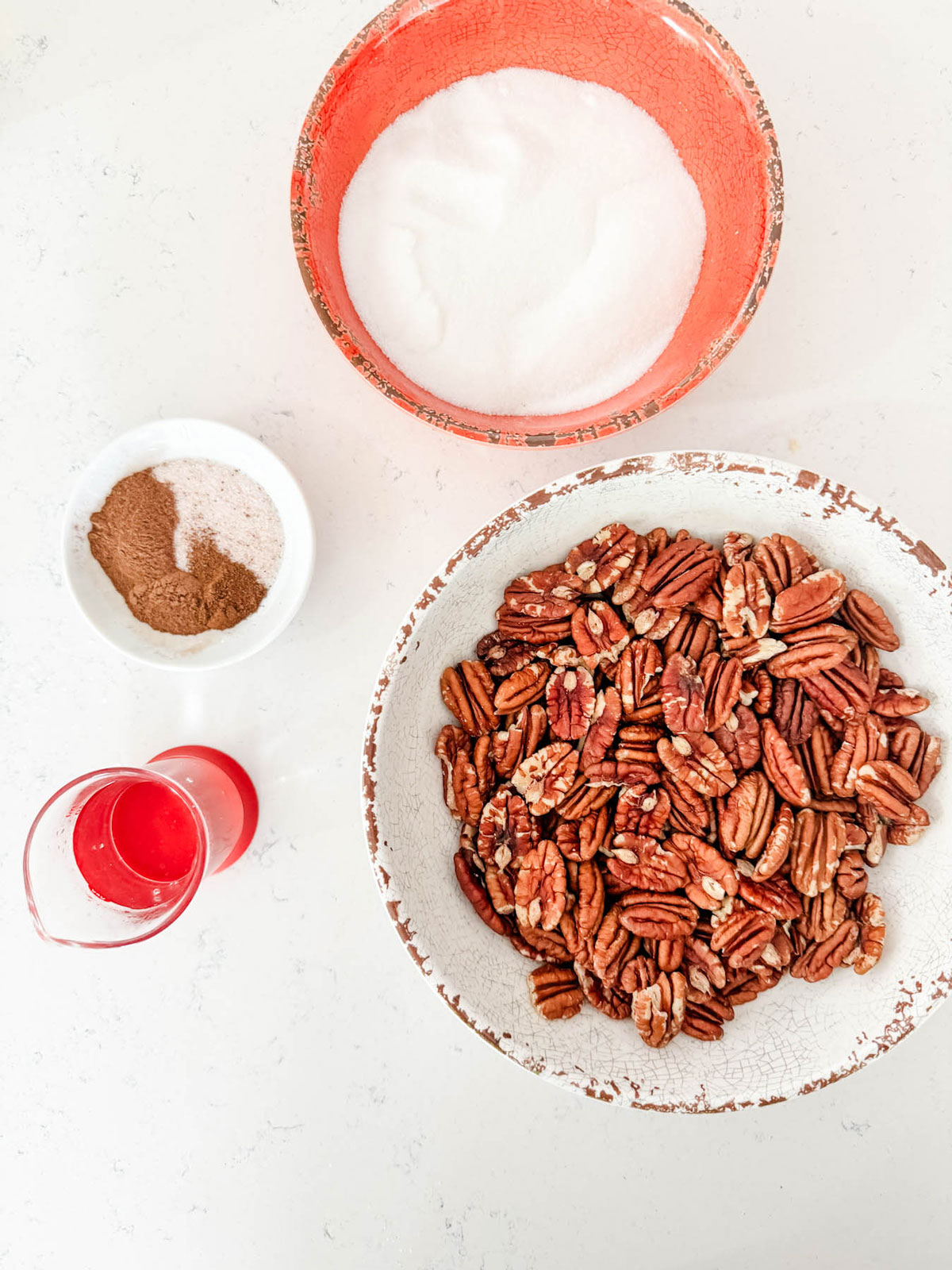 Overhead photo of a bowl of pecans, sugar, spices, and water.