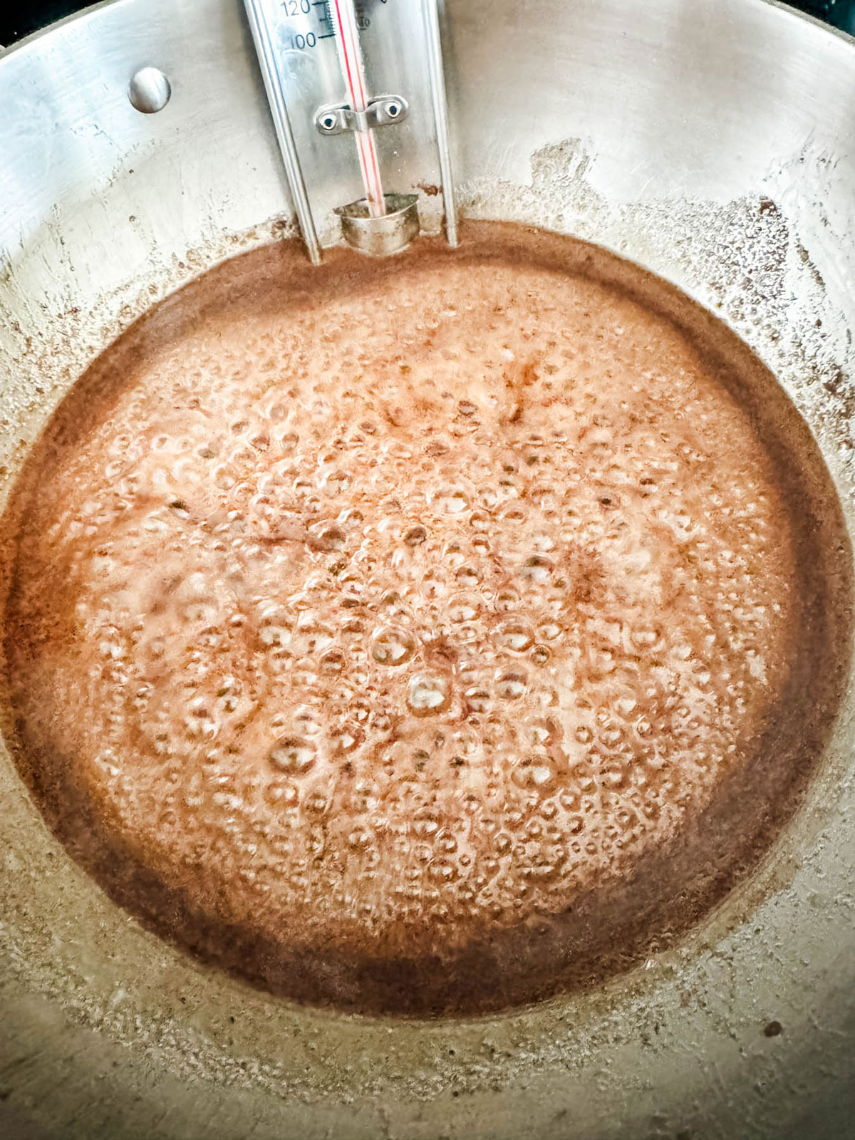 A spiced sugar mixture just starting to bubble in a saucepan.