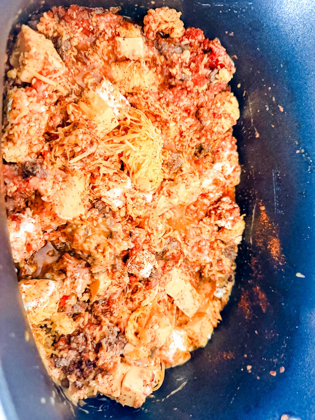 A close-up of a cheese dip in a slow cooker.