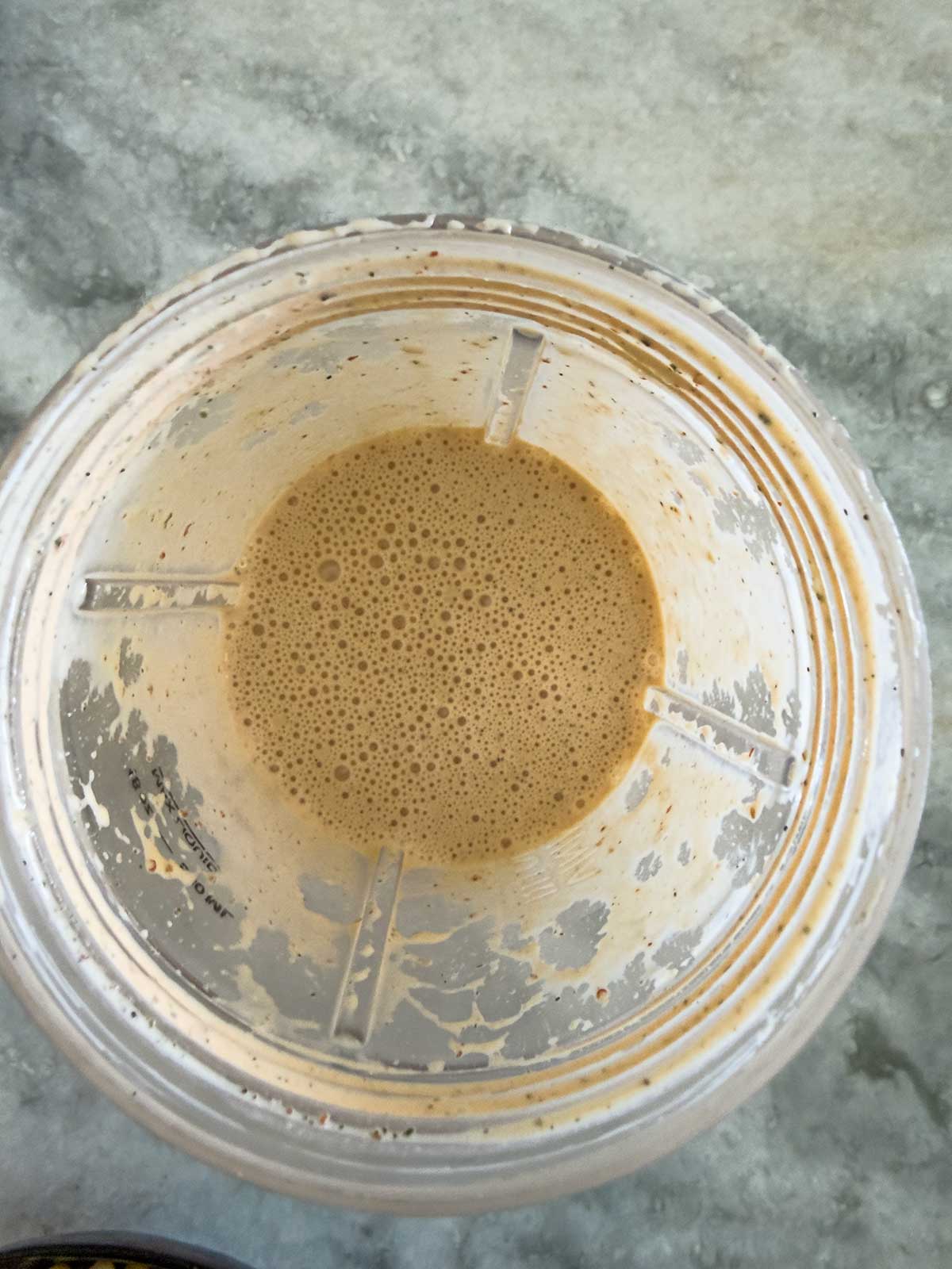 A top-down view of a blender cup containing chipotle ranch dressing.