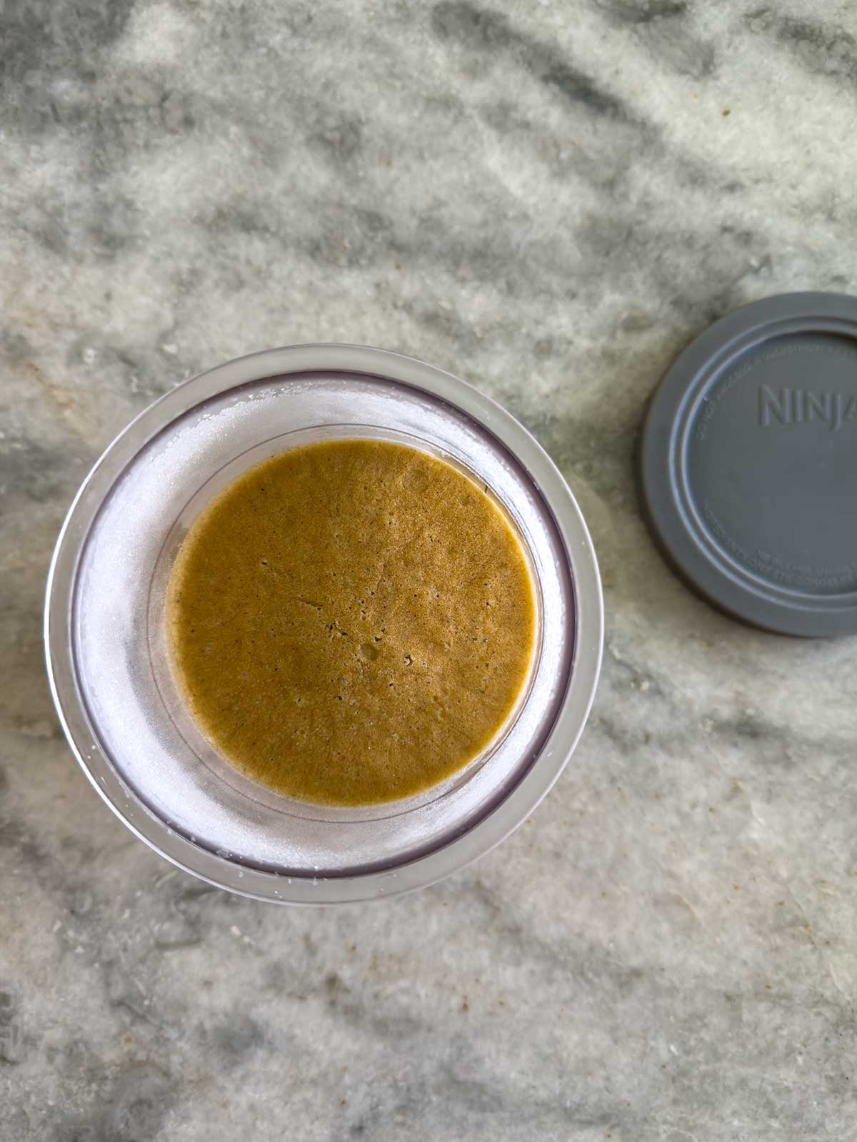 A top-down view of a glass jar with Ninja Creami pumpkin ice cream.
